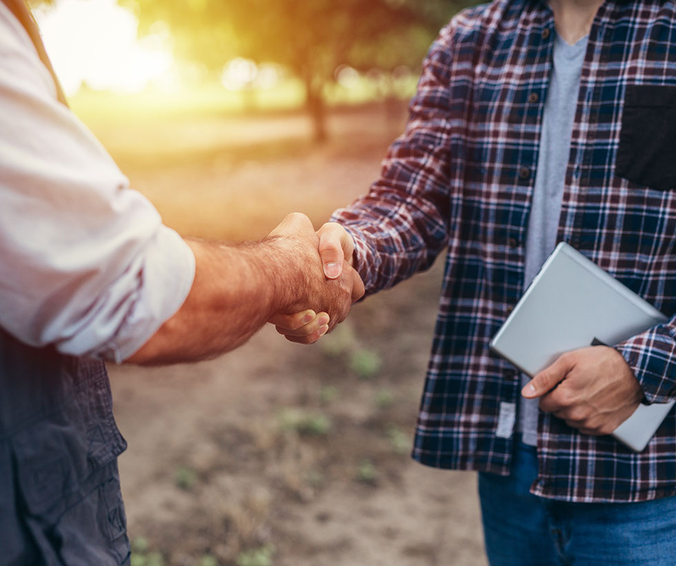 Men shaking hands outdoors.