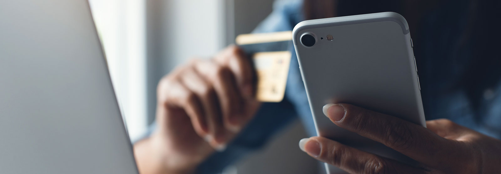 Woman holding phone and credit card.